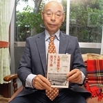 祖父が残した日記を前に、著書を持つ小泉義生さん＝神戸市西区