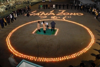 キャンドルの明かりで「１・１７　ＨＡＮＡＺＯＮＯ　つむぐ」の文字が浮かび上がった追悼集会＝明石市西明石南町１