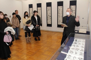 村上翔雲さんの作品について解説する六車明峰さん（右）＝明石市立文化博物館