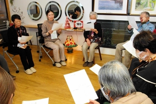 参加者と歌を歌う平子志津香さん（左から２人目）＝明石市材木町