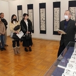 村上翔雲さんの作品について解説する六車明峰さん（右）＝明石市立文化博物館