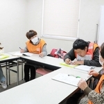 被災者役（右）の女性からニーズを聞き取るボランティア役の参加者たち＝明石市立総合福祉センター