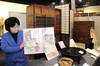 再現された板の間の前で、多聞新八さんの絵を紹介する担当者＝明石市立文化博物館