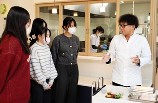 ベトナムのデザート「チェー」の作り方を説明するシェフの小沢亮吾さん（右）＝明石市大久保町大久保町