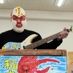 紙芝居を使った防災活動に取り組む福石健一さん。エレキギターで効果音を出す＝明石市内
