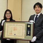 丸谷聡子市長（左）から紺綬褒章を伝達された裙本理人さん＝明石市役所