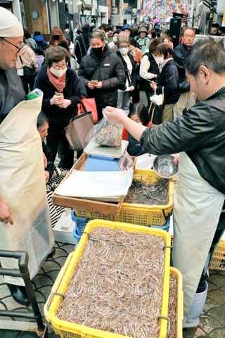 入荷したイカナゴを求め列を作る買い物客ら＝明石市本町１、松庄