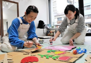 イベントの準備をする越山真衣さん（左）と角谷春佳さん＝明石市鍛治屋町