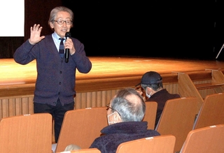 来場者に話しかけながら震災の教訓について話す堀内正美さん＝明石市東仲ノ町、子午線ホール
