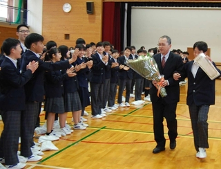 生徒にエスコートされ、拍手で見送られる阿部真人校長＝望海中学校