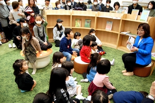丸谷聡子市長の絵本の読み聞かせに聞き入る子どもたち＝明石市二見町西二見駅前１