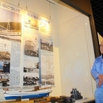 明石型生船の模型のそばに立つ金井清さん＝明石市立文化博物館