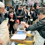 入荷したイカナゴを求め列を作る買い物客ら＝明石市本町１、松庄