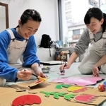 イベントの準備をする越山真衣さん（左）と角谷春佳さん＝明石市鍛治屋町