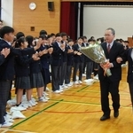 生徒にエスコートされ、拍手で見送られる阿部真人校長＝望海中学校
