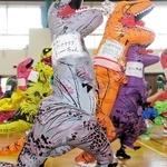 恐竜の着ぐるみを着て走る参加者ら＝明石市立勤労福祉会館