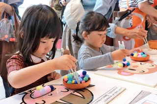 真剣な表情で箸を使う子ども＝あかし市民広場