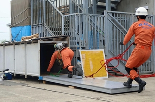 ほふく救出訓練で煙道に飛び込む隊員＝明石市藤江