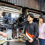 激しく焼けた店舗の前に立つ（左から）森本晃司さんと絢斗さん、まゆみさん＝明石市本町１