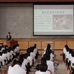 生徒らを前に、戦没者の遺骨収集の取り組みについて話す藤森龍さん＝二見中学校