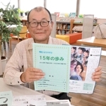 １５年の歩みをまとめた冊子と次回例会のチラシを持つ金沢昇代表＝明石市東仲ノ町