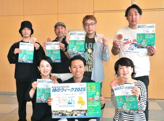 記念式典で配る記念品とポスターを手にする実行委員会メンバーら＝明石市大明石町１