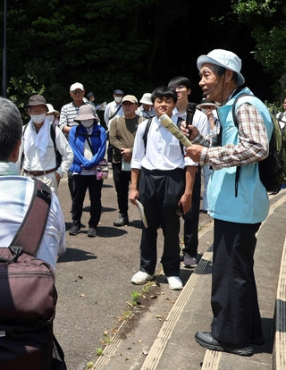 牧野満徳さん（右）の話を聞く参加者ら＝明石市明石公園