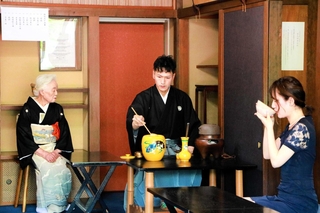 参列者らにふるまう薄茶をたてる多田翔一郎さん（中央）と見守る伊原宗静さん（左）＝明石市大久保町西島