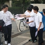 自転車で登校した生徒にチラシを渡し、注意を呼びかける生徒会役員ら＝明石商業高校
