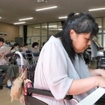 多久島晶子さんの演奏に合わせて口ずさむ参加者ら＝明石市沢野１