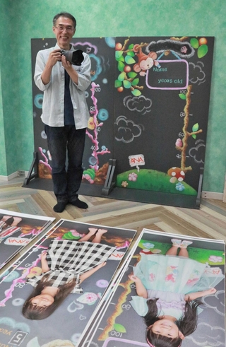 子どもたちの等身大の写真を並べ、イベントの準備をする阿那守男さん＝明石市西明石南町１