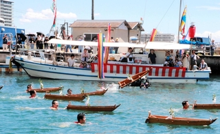 沖に向かって小舟を投げ飛ばす氏子ら＝明石港