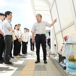 事故現場となった歩道橋で、新入職員へ当時の状況などを語る下村誠治さん＝明石市大蔵海岸通１