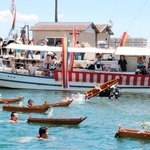 沖に向かって小舟を投げ飛ばす氏子ら＝明石港