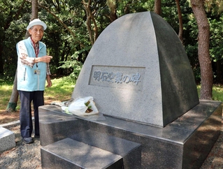 「明石空襲の碑」について解説する牧野満徳さん＝県立明石公園
