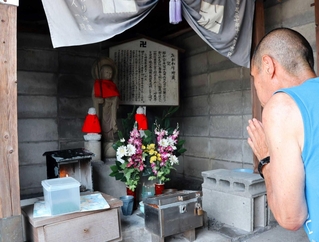 動員学徒らの慰霊のために建てられた「みがわり地蔵」を拝む人＝明石市川崎町