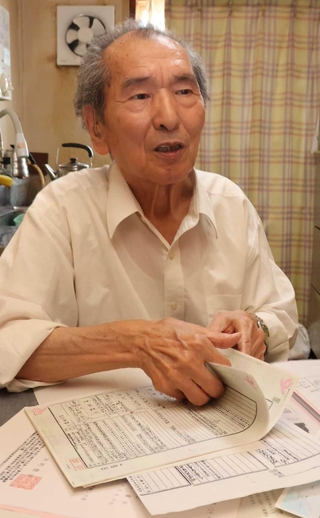 戸籍を見ながら、家族への思いを語る小林弘さん＝神戸市西区枝吉１