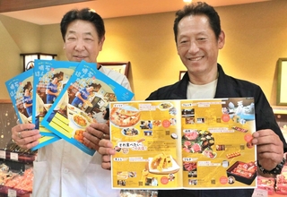 グルメガイド冊子を手にする松下要一理事長（右）と原田貞副理事長＝明石市本町１