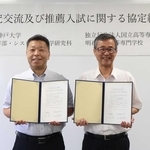 署名した協定書を手に持つ（左から）神戸大学の臼井英之システム情報学部長と明石高専の土居信数校長＝明石市魚住町西岡
