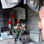 動員学徒らの慰霊のために建てられた「みがわり地蔵」を拝む人＝明石市川崎町
