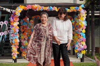 思い出の着物から仕立て直した服を着て、笑顔で歩く芦谷温子さん＝明石市大久保町大窪