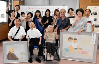 作品展の会場で親族に囲まれる井登延和さん（前列左から３人目）と慧さん（同２人目）＝ふれあいプラザあかし西