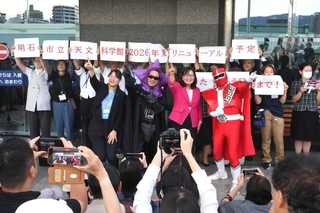 記念撮影に応じる（前列右から）シゴセンジャーレッド、丸谷聡子市長、ブラック星博士ら＝明石市立天文科学館