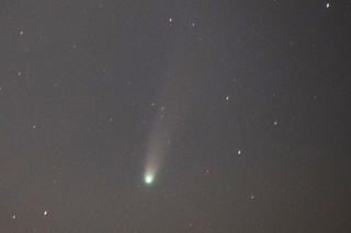 尾を引く緑がかったレモン彗星＝29日午後６時43分、明石市二見町東二見（四元照道さん提供）