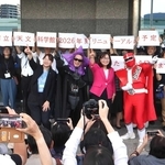 記念撮影に応じる（前列右から）シゴセンジャーレッド、丸谷聡子市長、ブラック星博士ら＝明石市立天文科学館