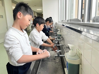 インフルエンザなどの感染予防をしようと、手洗いする人丸小学校の児童ら＝明石市東人丸町