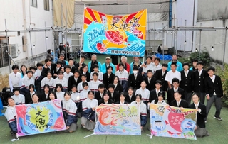 大漁旗をお披露目した錦城中２年生と魚の棚商店街の関係者ら＝明石市本町１