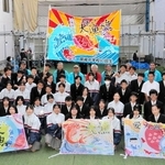 大漁旗をお披露目した錦城中２年生と魚の棚商店街の関係者ら＝明石市本町１