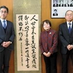 山内佐太郎がしたためた掛け軸を明石高校に寄贈した中本栄美子さん（中央）、原田良弘さん（右）と受け取った同校の泉村靖治校長＝明石市荷山町