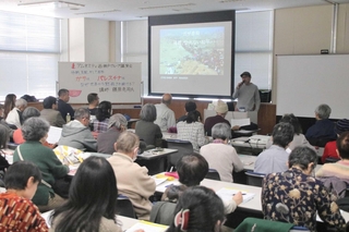 パレスチナの現状を解説する藤原亮司さん（奥）と参加者ら＝明石市東仲ノ町